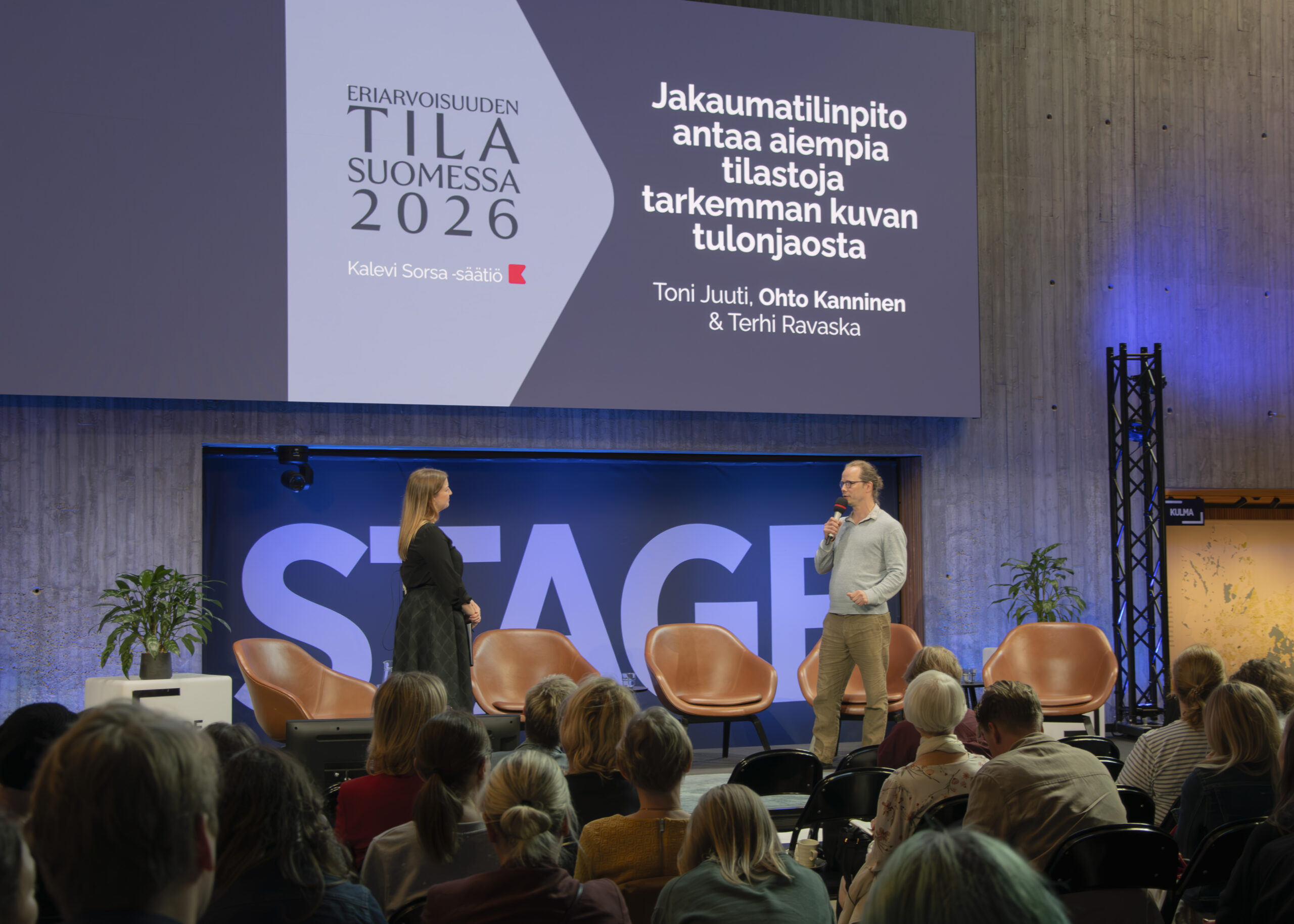Ohto Kanninen esittelee tutkimusta tapahtumassa Keskustelutilaisuus: Eriarvoisuuden tila Suomessa 2026, juontaja Alma Onali kuuntelee