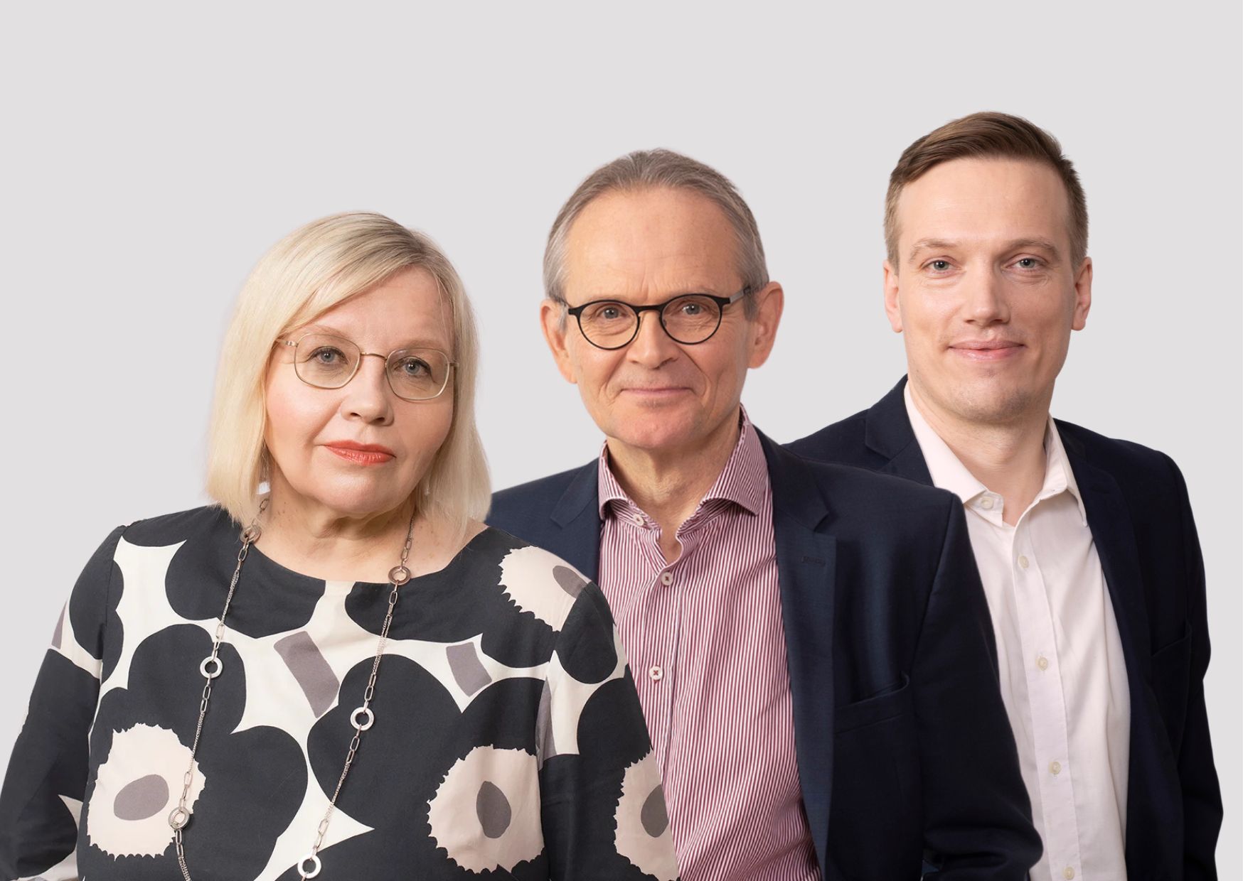 Ryhmäkuva vaalean harmaalla taustalla. Vasemmalla Merja Kauhanen kuosillisessa puserossa ja silmälaseissa, keskellä silmälasipäinen Ilkka Kiema raidallisessa kauluspaidassa ja bleiserissä, oikealla Juho Koistinen valkoisessa paidassa ja tummansinisessä bleiserissä.